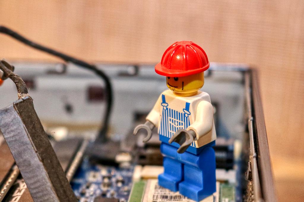 Close-up of hands fixing a laptop component